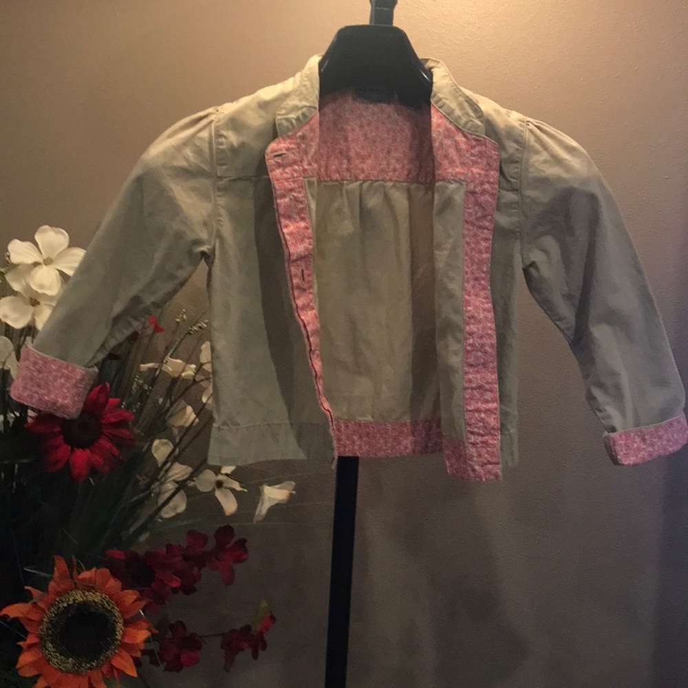 Adorable tan jacket w/ sweet pink flower trim.